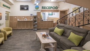 Un área de recepción con un sofá, sillas y un mostrador de madera.