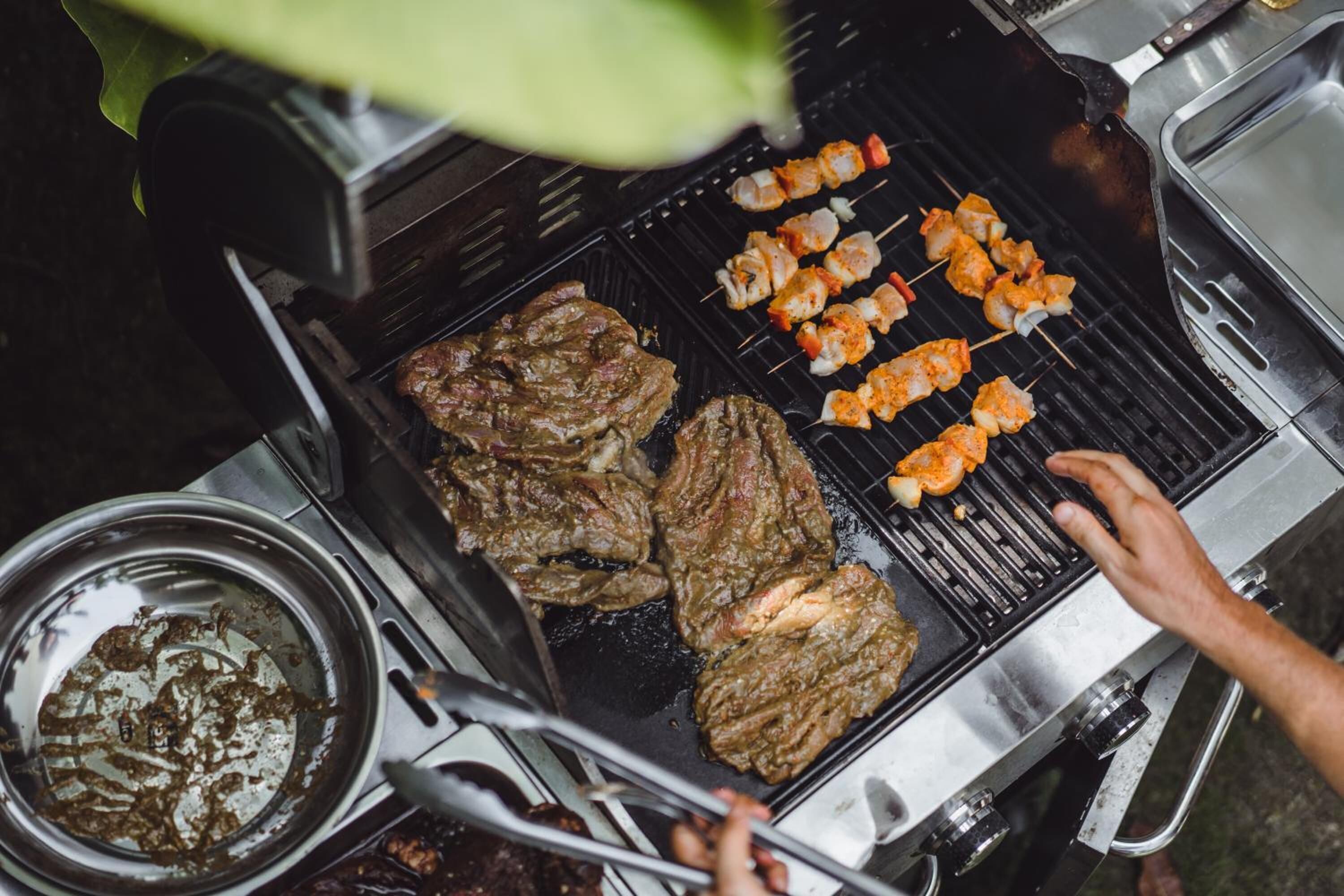A grill with various meats and skewers being cooked.