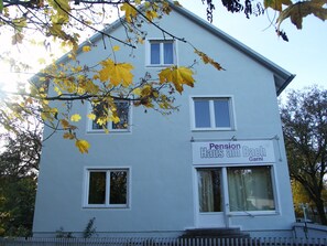 A two-story building with a sign that reads "Pension Haus am Bach Garni". - ARRIVEL Pension Haus am Bach (Allershausen)