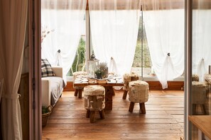 A cozy room with a wooden floor, a sofa, and a table with stools.