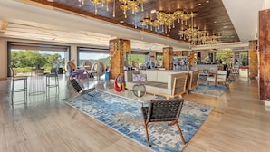A spacious hotel lobby with a modern design, featuring a large seating area, a bar, and a view of the outdoors. - Planet Hollywood Costa Rica by Royalton, An Autograph Collection All-Inclusive Resort (Nacascolo)