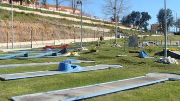 Un parque con varias trampolines y una zona de césped.