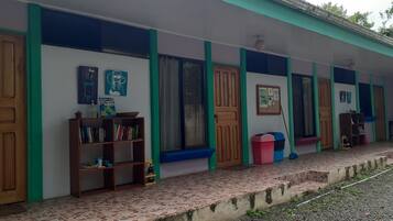 Stylish rooms feature wooden doors, windows with curtains, and a bookshelf with a collection of books and decorative items.