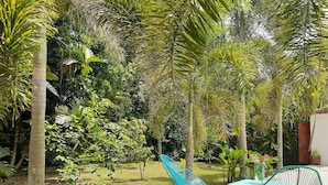 A patio area with two chairs, one blue and one green, and a table.