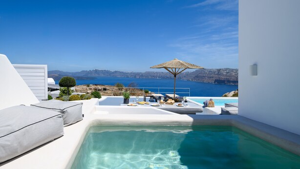 A modern outdoor pool area with a clear view of the sea and mountains. - Cape 9 Suites & Villas (Santorini)