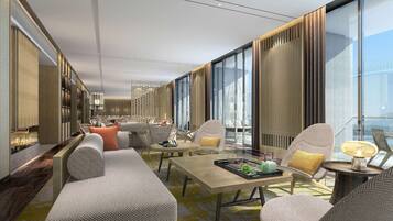 A modern hotel lobby with a long seating area, a fireplace, and large windows offering a view of the city.