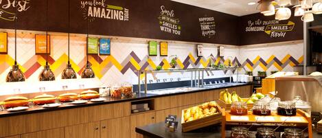 A breakfast buffet area with various food items and condiments.