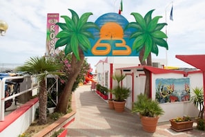 A pathway leading to a building with a sign reading "BAGNO ROSA" and a large number "63" above it. - Hotel Villa Donati (Rimini)