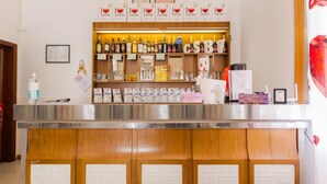 A bar area with shelves of various beverages, a counter with a menu, and a wooden panel design. - Hotel Villa Donati (Rimini)