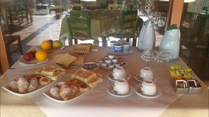 Un bufé de desayuno con diversos pasteles, frutas y bebidas.