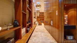 A hallway with wooden paneling, a marble floor, and various vintage items displayed on shelves. - Nido x Palermo Soho Square (Buenos Aires)