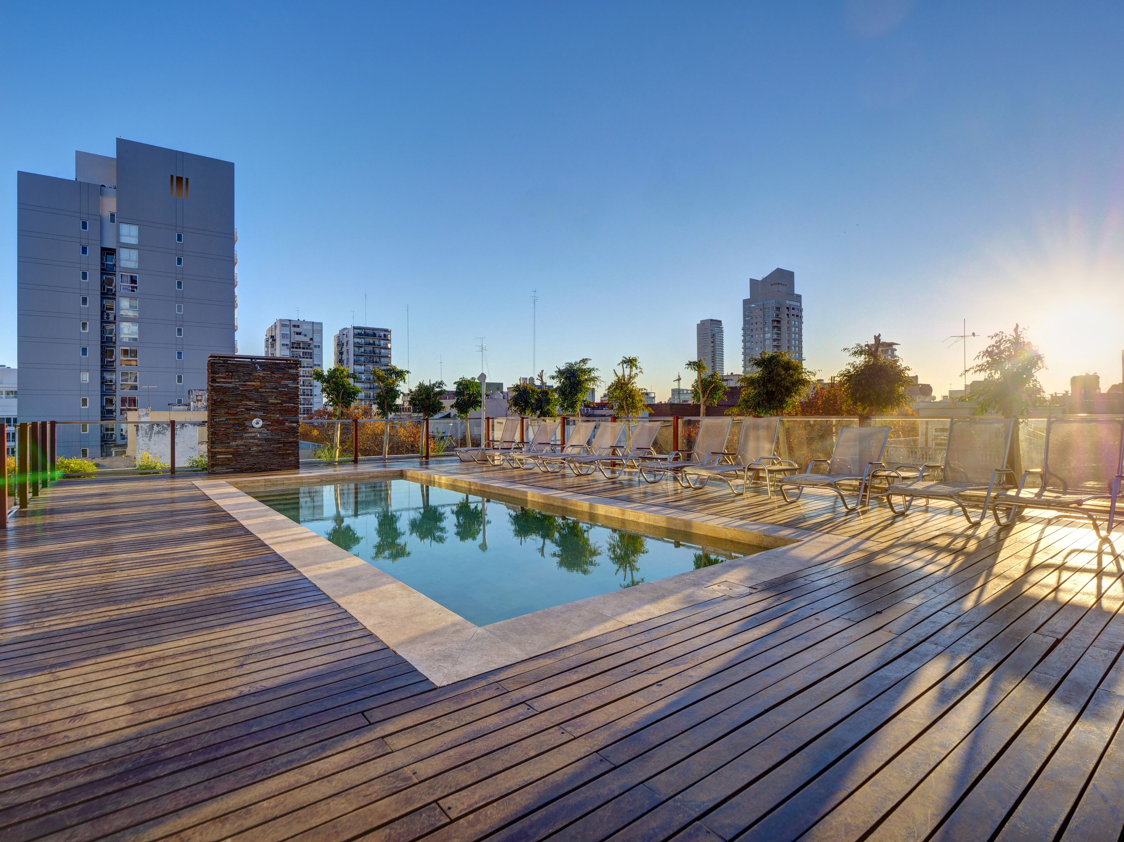 Una piscina al aire libre, sillones reclinables de piscina