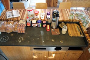 A kitchen counter with various food items and kitchen tools. - The Crash Pad - An Uncommon Hostel (Chattanooga)