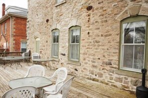 A stone building with a patio area featuring a table and chairs.
