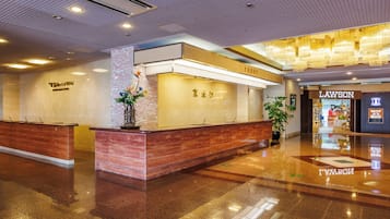 A hotel lobby with a reception desk, a 'Front' sign, and a 'Lawson' store.