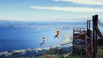 A high-altitude zip-lining activity with a clear view of a coastal landscape.