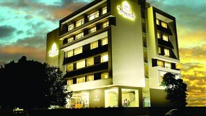A multi-story hotel with a modern design, featuring a prominent sign and multiple illuminated windows. - Dwarawata Dharwad (Dharwad)