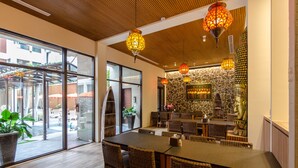 A modern dining area with wicker furniture, large windows, and decorative lanterns. - Move Resort & Spa (Tainan)