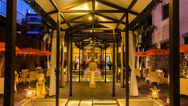 A covered outdoor area with tables and chairs, a central decorative light, and potted plants. - Move Resort & Spa (Tainan)