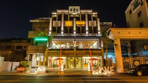 A hotel with a prominent 'MOVE' sign, a large 'LOVE' sign, and a well-lit entrance with umbrellas. - Move Resort & Spa (Tainan)