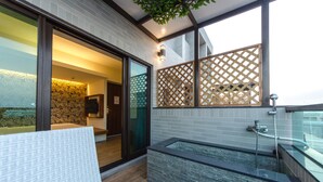 A modern bathroom with a glass-enclosed shower, a built-in bathtub, and a wooden privacy screen. - Move Resort & Spa (Tainan)