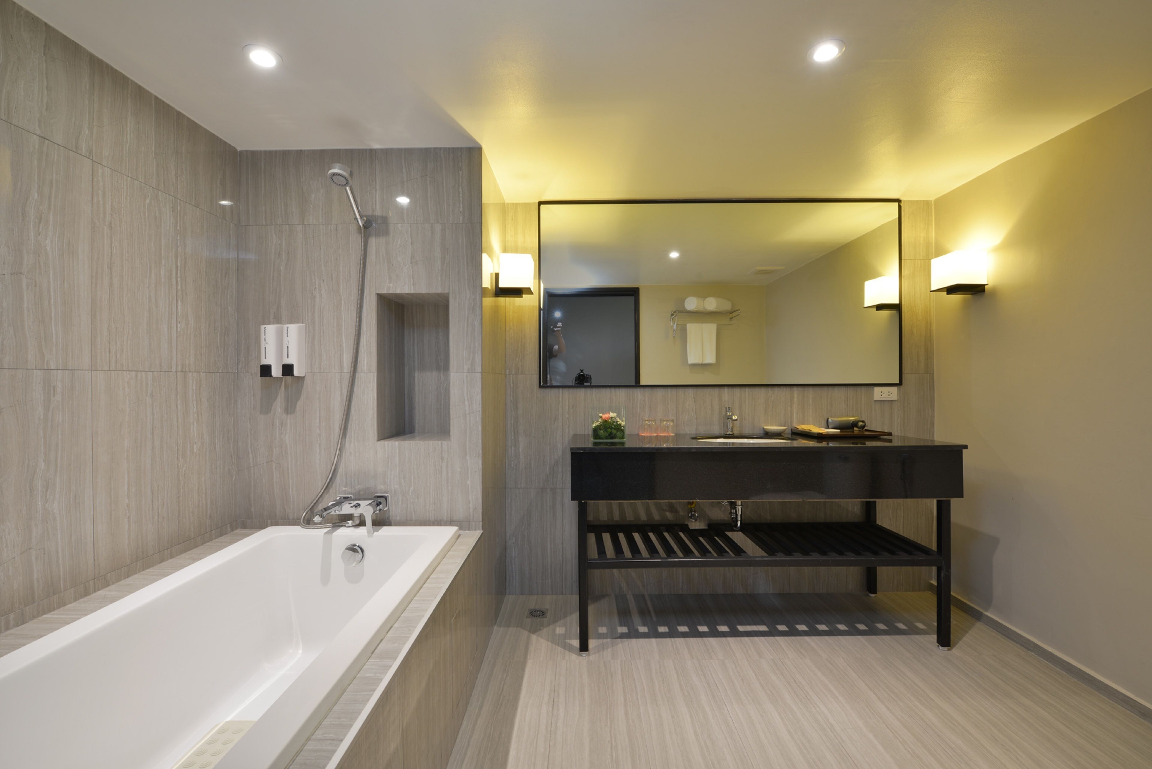 Un baño moderno con bañera, tocador con espejo y ducha.
