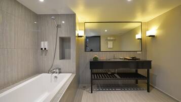 Un baño moderno con bañera, tocador con espejo y ducha.