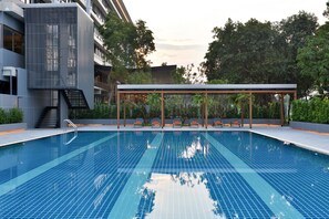 Relax by the rectangular pool surrounded by lounge chairs and a covered seating area.