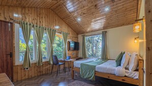 A wooden cabin room with a bed, desk, chair, and TV. - Nature Drops (Kosiyakutoli)
