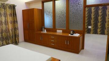 A bedroom with a wooden wardrobe, a bedside table, and a bed.