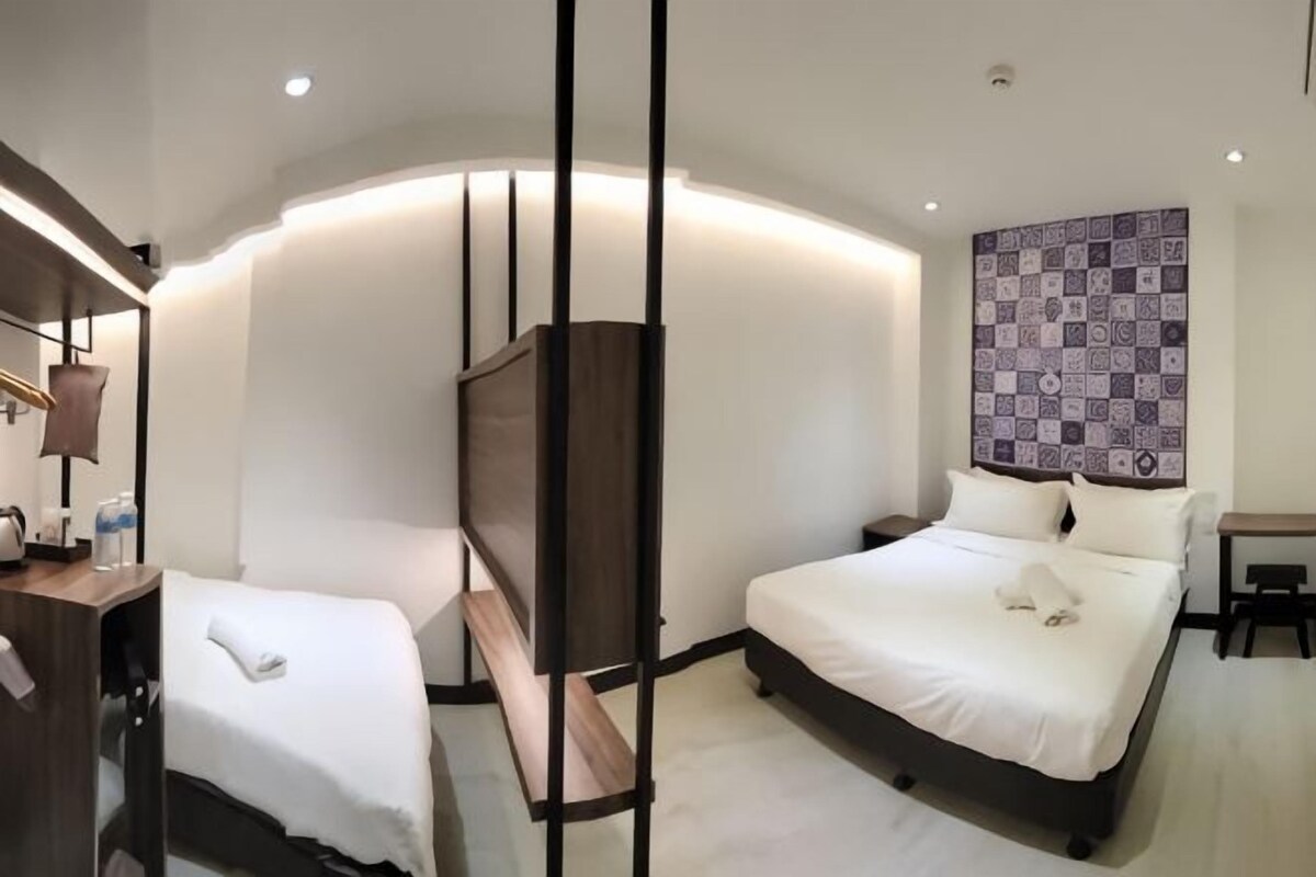 Ein Hotelzimmer mit zwei Betten, einer großen Wandteppich und einem modernen Design.