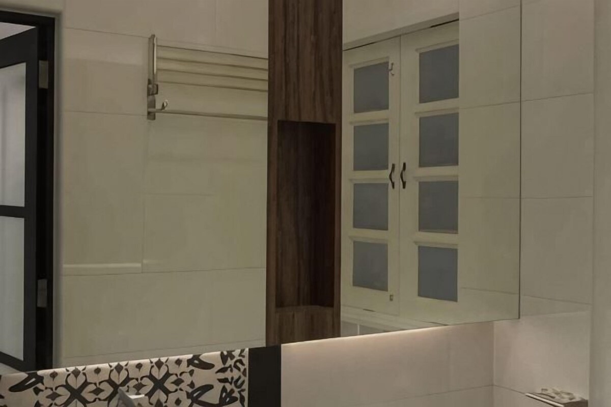 A bathroom with a mirror, a towel rack, and a cabinet.