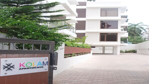 A gated entrance to a modern apartment complex with a sign reading "KOLAM APARTMENTS". - Kolam Serviced Apartments - Adyar (Chennai)