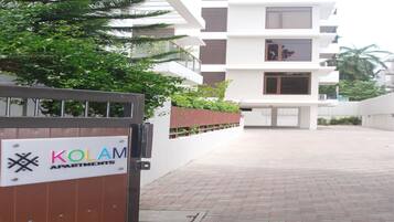 Enter the KOLAM APARTMENTS, a residential complex with modern architecture and balconies.