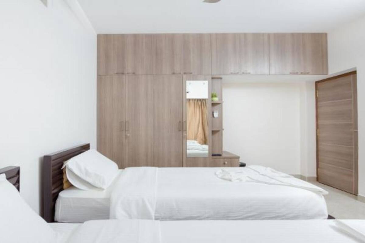 Quarto com cama, guarda-roupa e espelho.