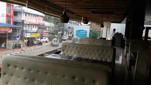 A restaurant with a view of the street, featuring a counter and seating area. - Aroma Classic Days (Thiruvananthapuram)