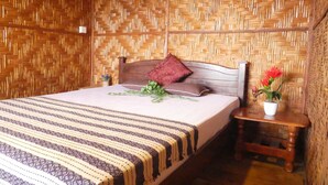 A room with a bed, a nightstand, and a woven wall. - Bakau Hijau Riverlodge - Hostel (Bedung)