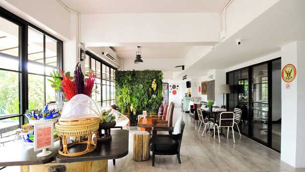 A spacious, modern interior with a dining area, a bar, and a living space with a green wall and large windows.