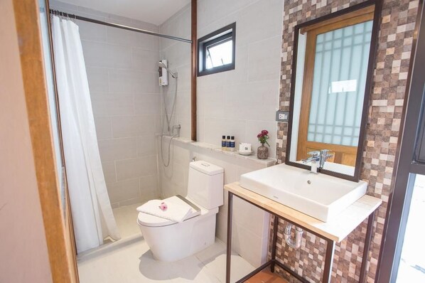 A bathroom with a shower, toilet, and sink.