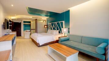 Una habitación de hotel moderna con una cama, un sofá, una mesita de madera y un escritorio.