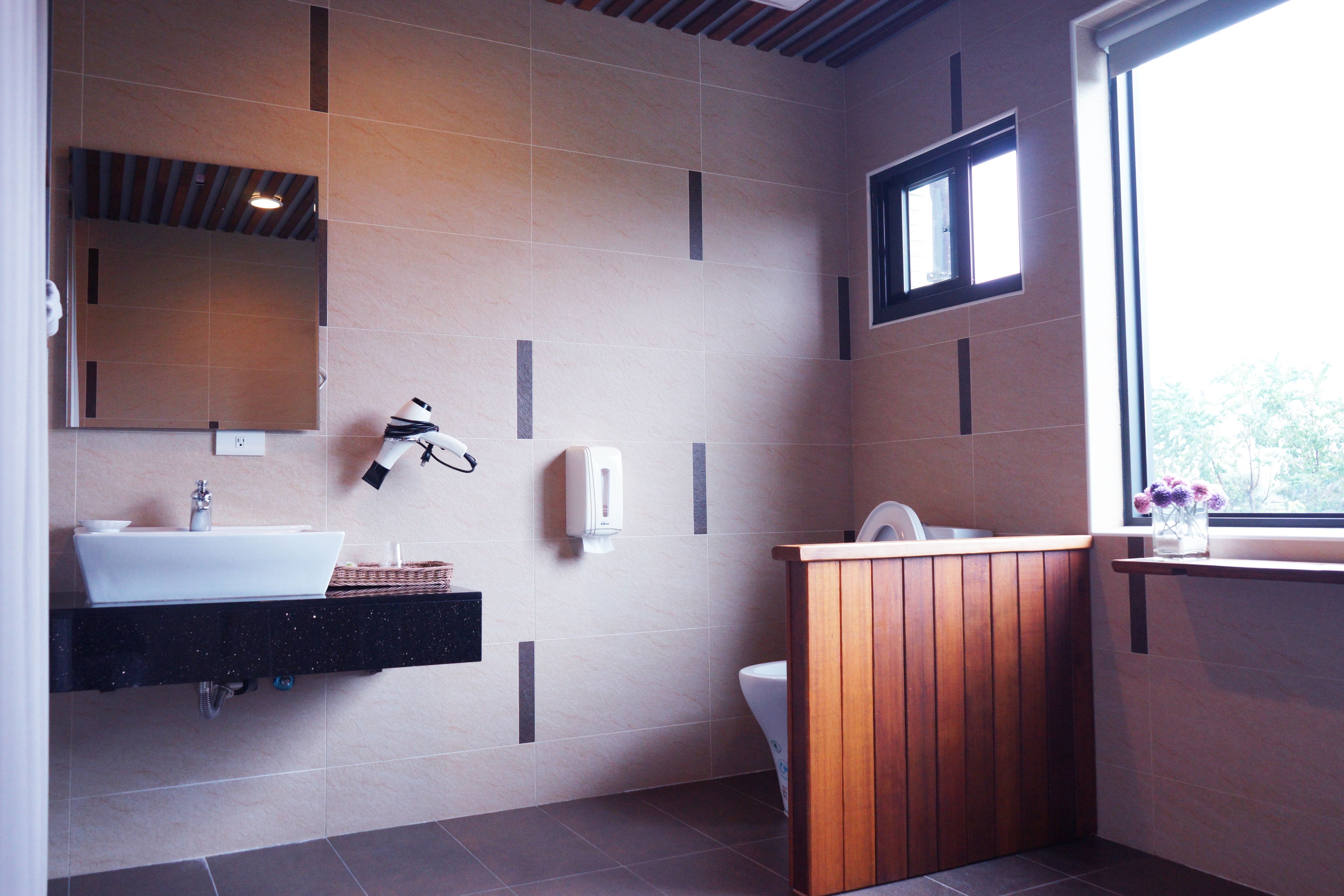 Un baño moderno con un espejo grande, un lavabo, un inodoro y un mueble de tocador de madera.