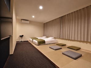 Une chambre d’hôtel avec un lit, un bureau et une grande fenêtre avec des rideaux.