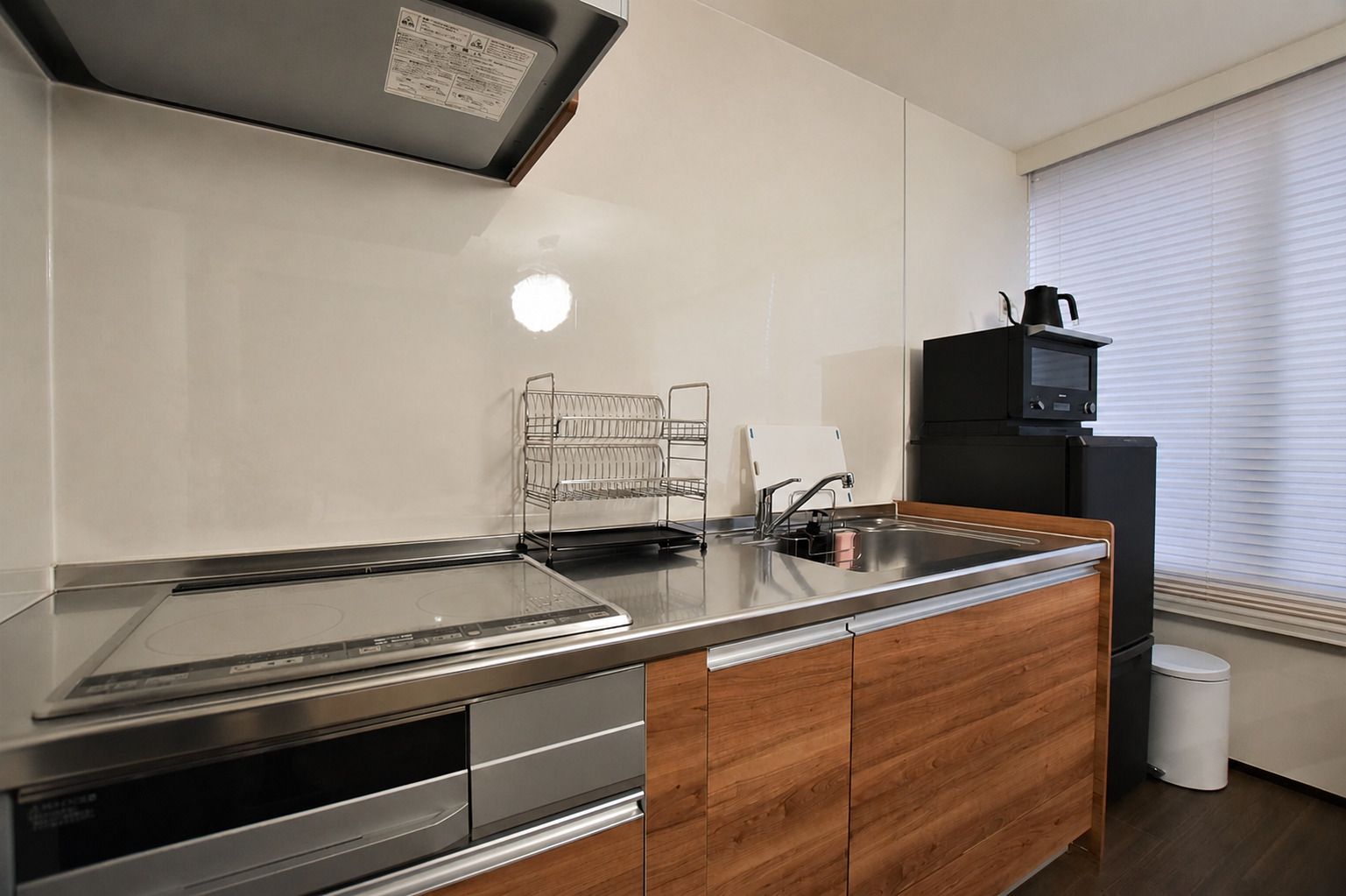 A modern kitchen with a built-in stove, a sink, and a microwave.