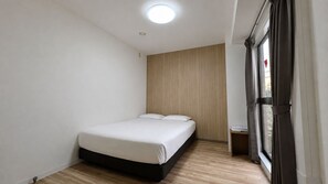 Un dormitorio pequeño y moderno con una cama individual, un revestimiento de madera y una ventana con cortinas.