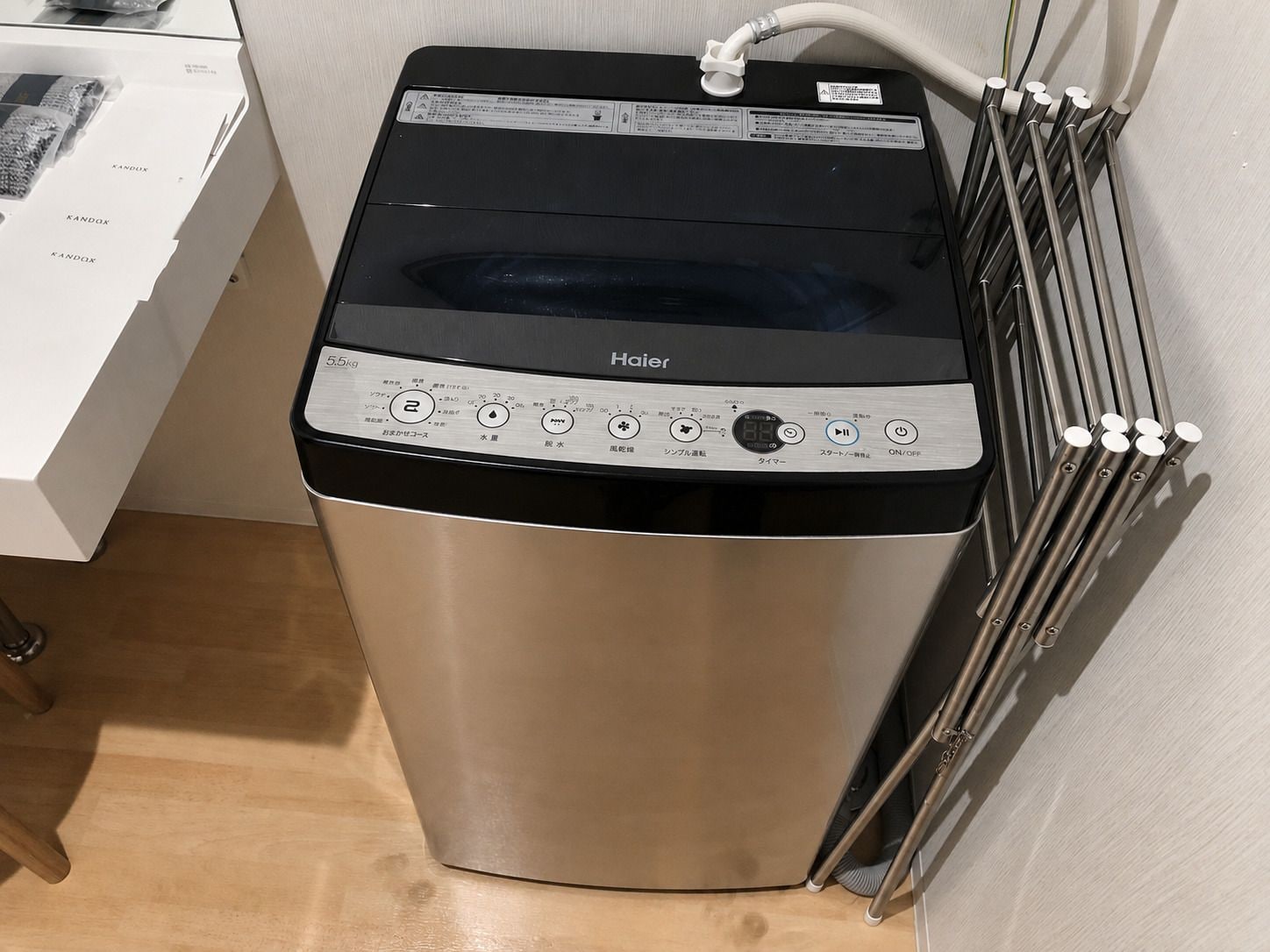 Un electrodoméstico compacto de acero inoxidable, probablemente una lavadora o secadora, con pantalla digital y panel de control.