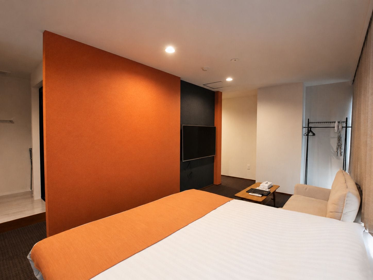 A hotel room with a large bed, a flat-screen TV, a desk, and a seating area.