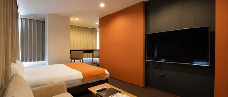 A hotel room with a bed, a sofa, a TV, a table with a remote and a tissue box, and a window with curtains.