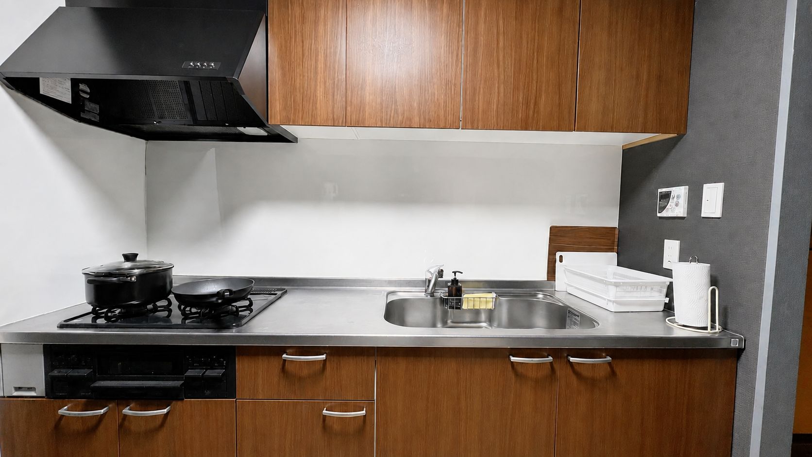 Una cocina moderna con estufa, lavamanos y armarios de madera.