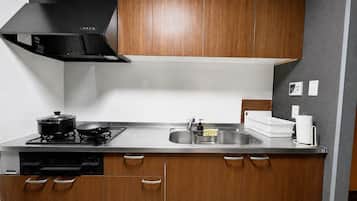 Una cocina moderna con estufa, lavamanos y armarios de madera.