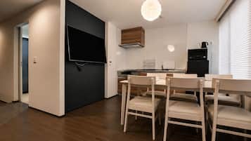 Una cocina moderna con comedor, suelo de madera y televisor de pantalla plana.